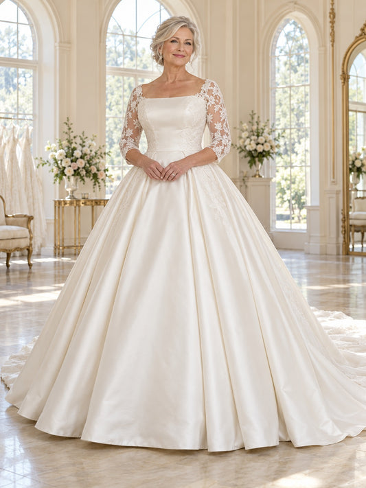 Vestido de novia de satén y encaje en marfil, corte princesa, escote cuadrado, manga al codo y cola corta