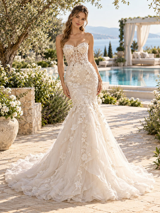 Vestido de novia de encaje y tul en marfil, corte sirena, sin tirantes y escote corazón y cola capilla