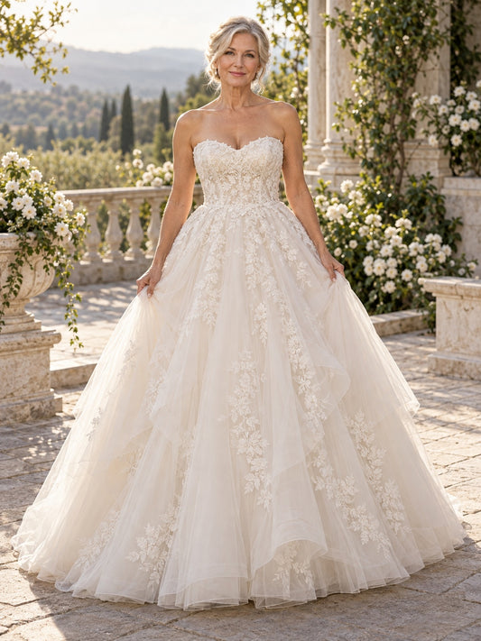 Vestido de novia de encaje y tul en marfil, corte princesa, sin tirantes y escote corazón y cola capilla