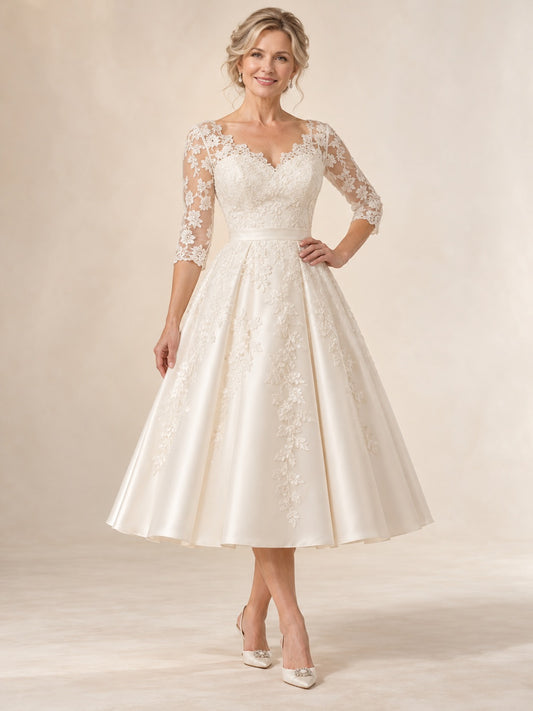 Vestido de novia de satén y encaje en marfil, línea A, escote corazón, manga tres cuartos y largo a media pierna