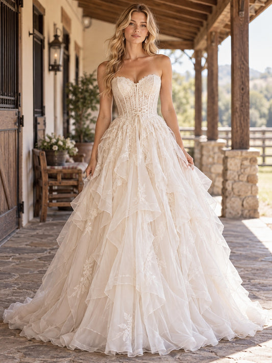 Vestido de novia de tul y encaje en marfil, corte princesa, sin tirantes y escote corazón y cola capilla