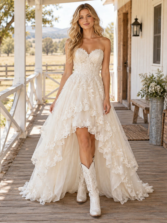 Trägerloses, herzförmig ausgeschnittenes, gestuftes A-Linien-Brautkleid im Western-Stil mit Spitzenbesatz und asymmetrischem Saum